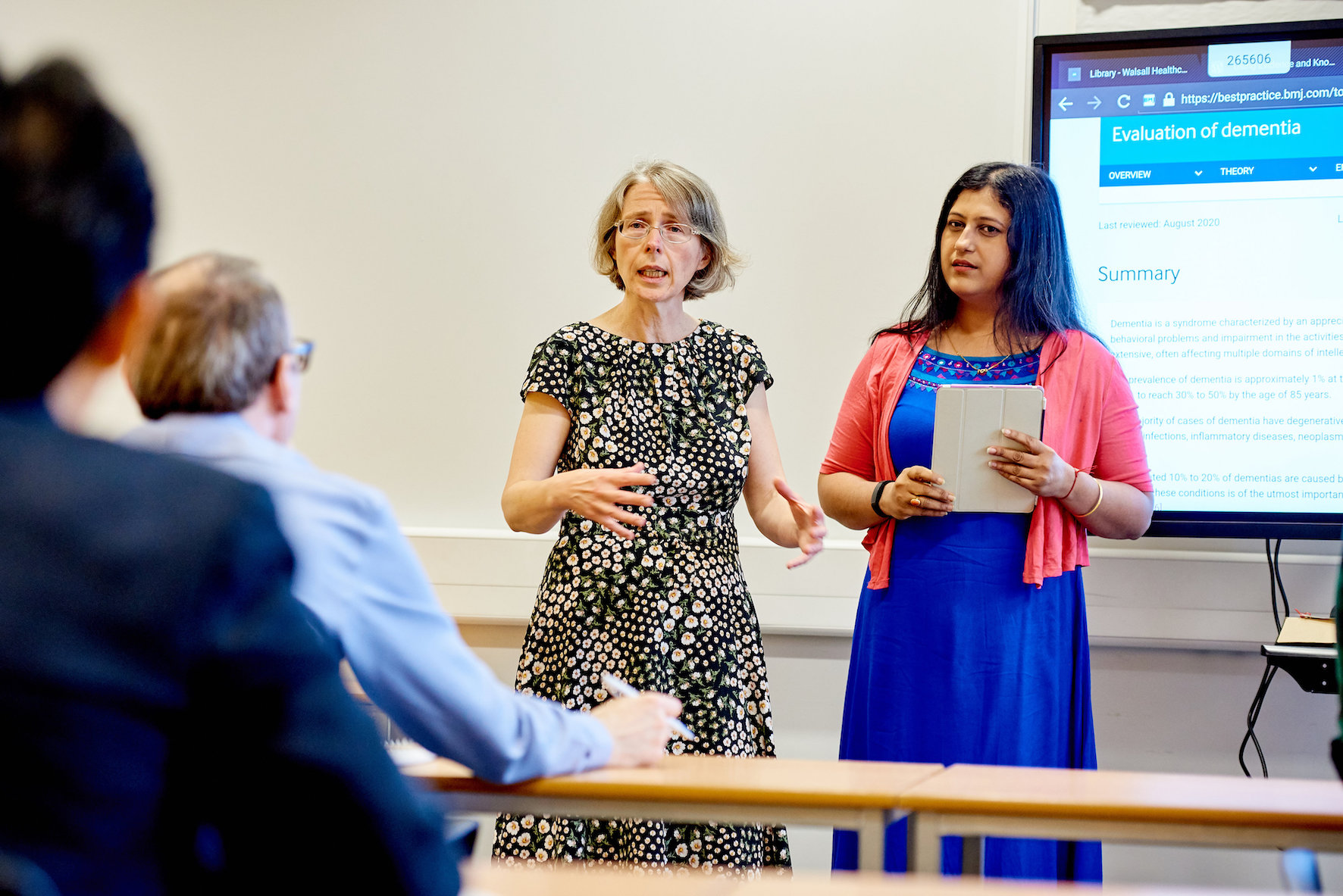 An image of 2 library professionals leading a meeting.