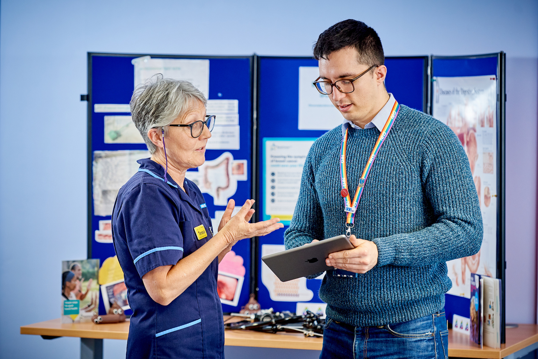 An image of a female librarian in discussion with a male clinician.