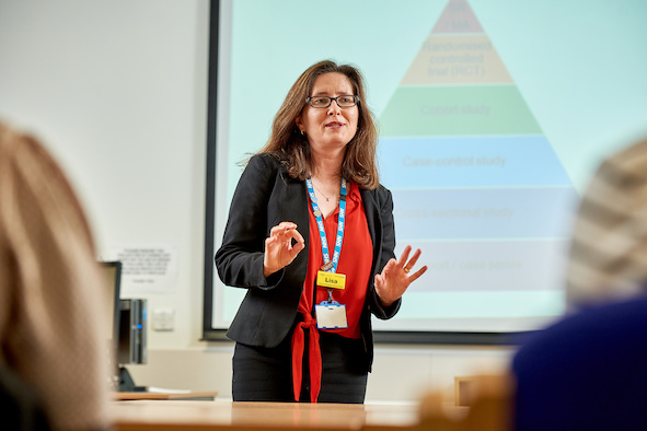 Library professional leading a meeting in front of an infographic