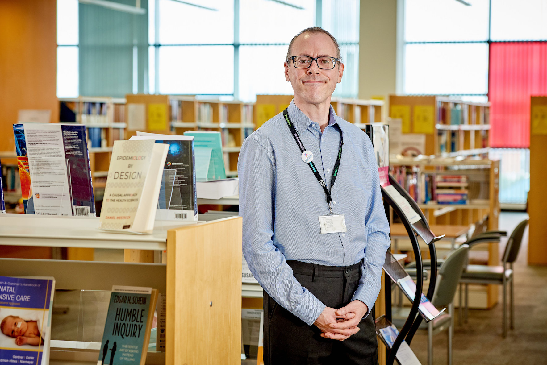 Library professional in front of bookshelves